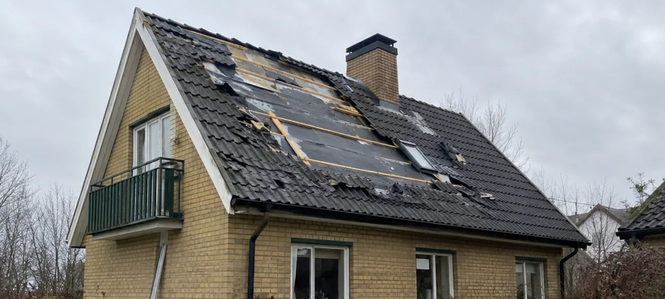 Före: ett sadeltak på ett gult tegelhus där stormen har slitit loss många takpannor, så att läkt och underlag syns.